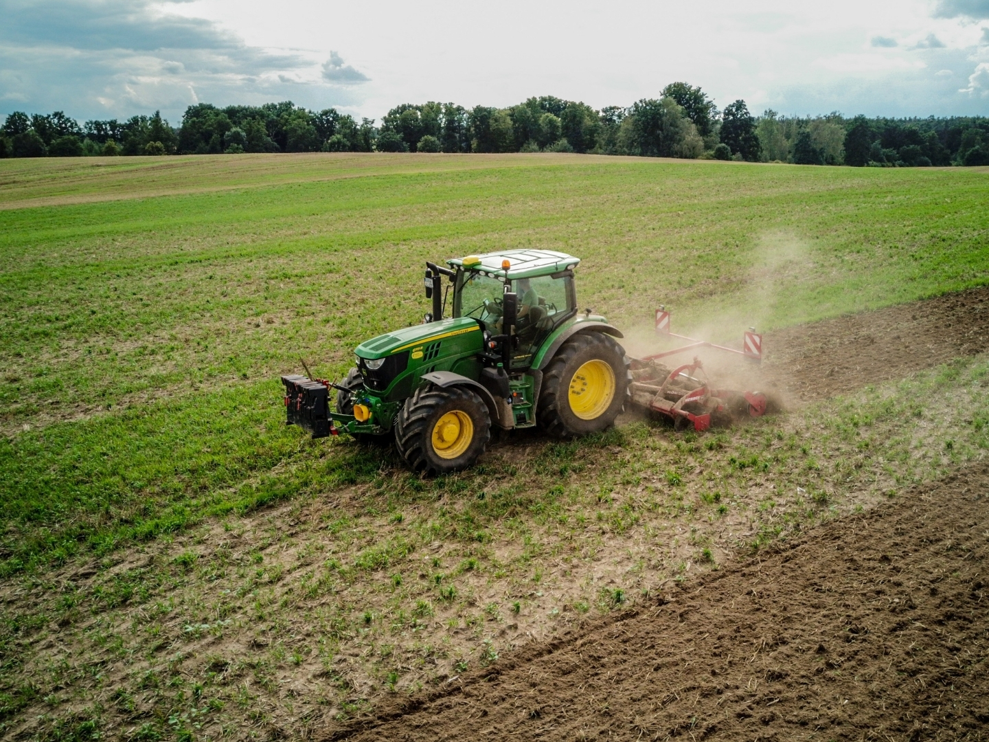 Tractor working in a productive agricultural field surrounded by open countryside.