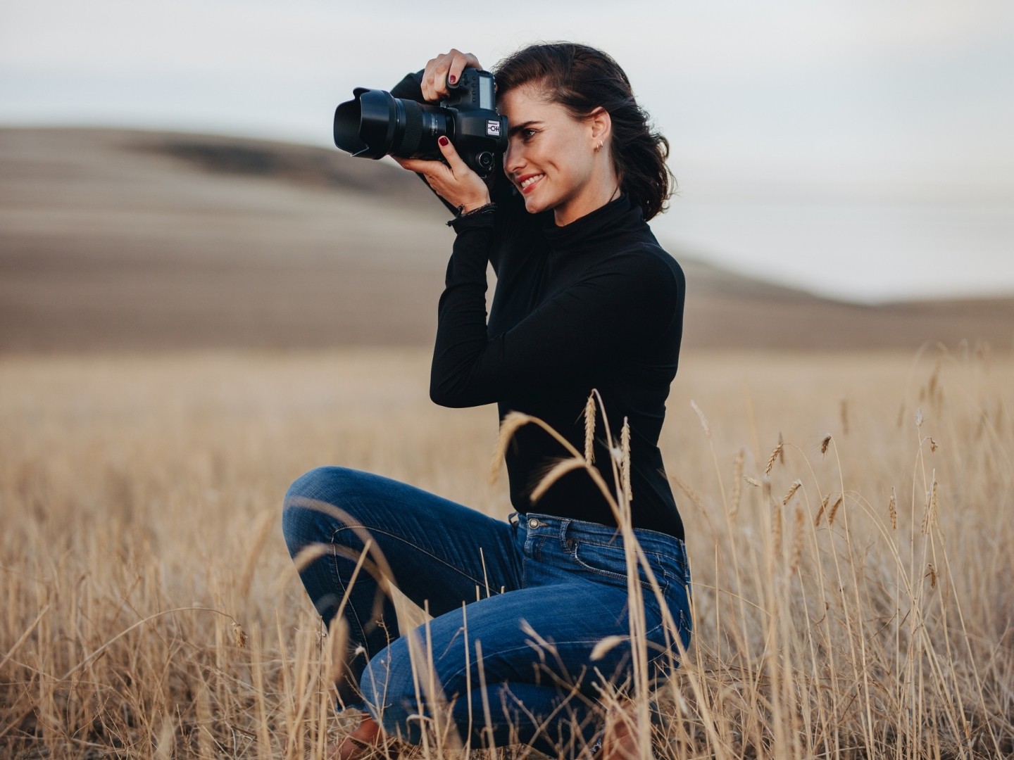 Person photographing wildlife in the countryside to help record local species and habitats.
